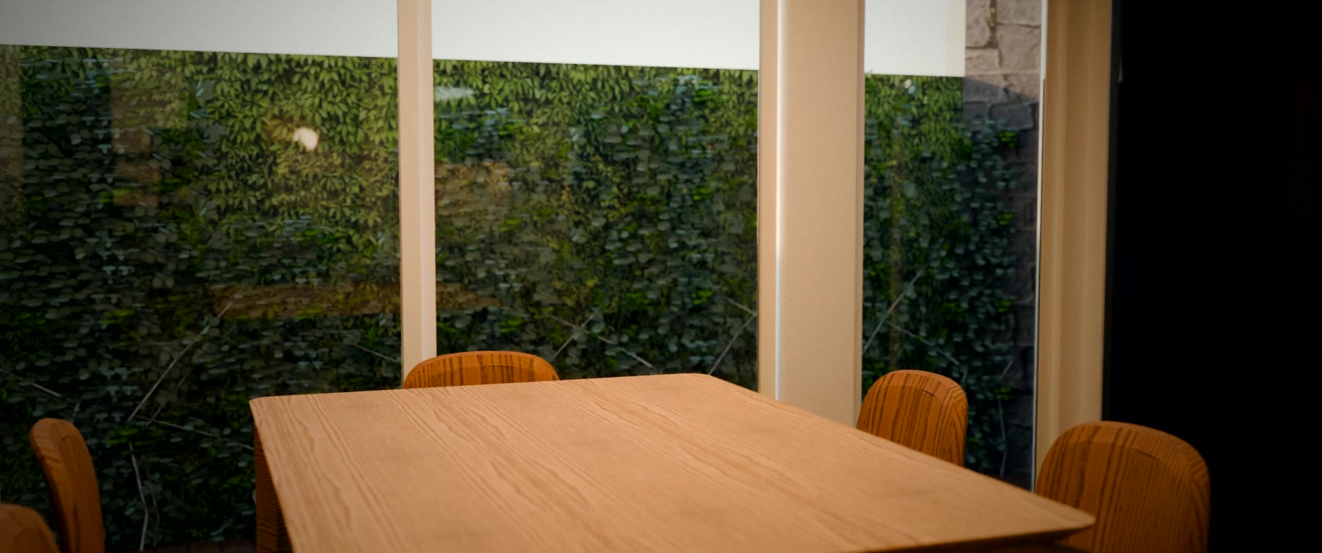Mesa de jantar de madeira diante de portas de vidro e jardim vertical.
